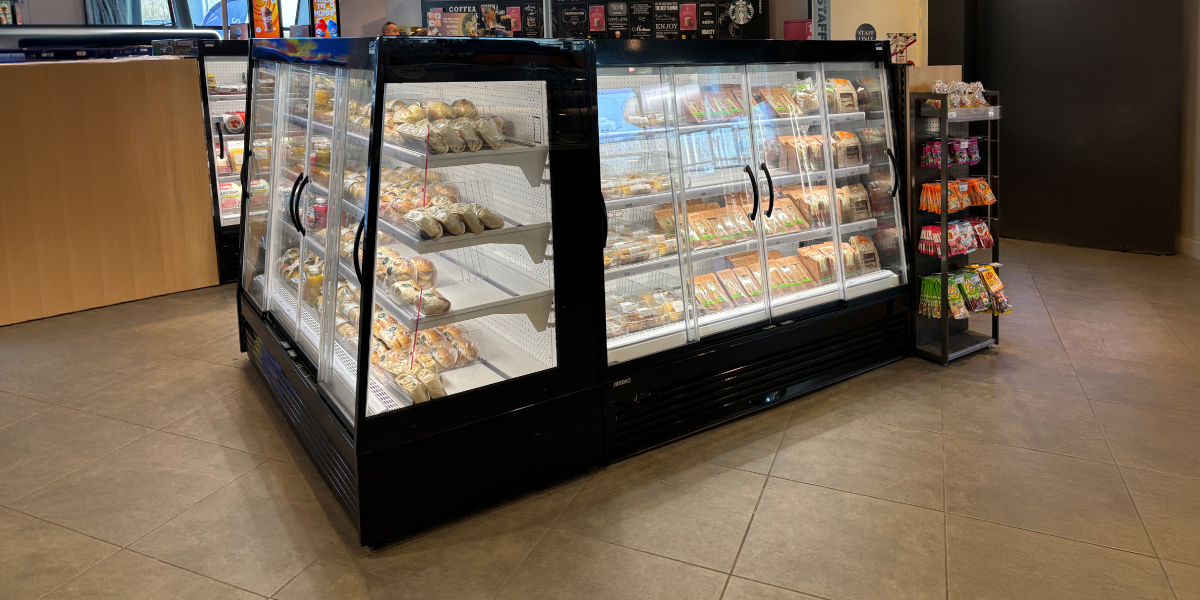 Linha cont&iacute;nua de expositores alimentares refrigerados em &aacute;rea comercial